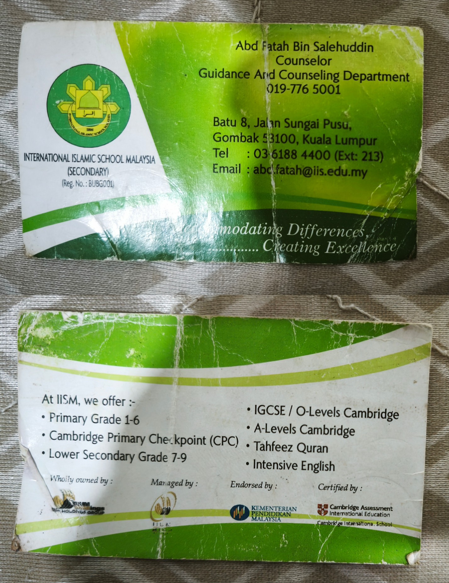 Both sides of my worn out school counselor's business card.